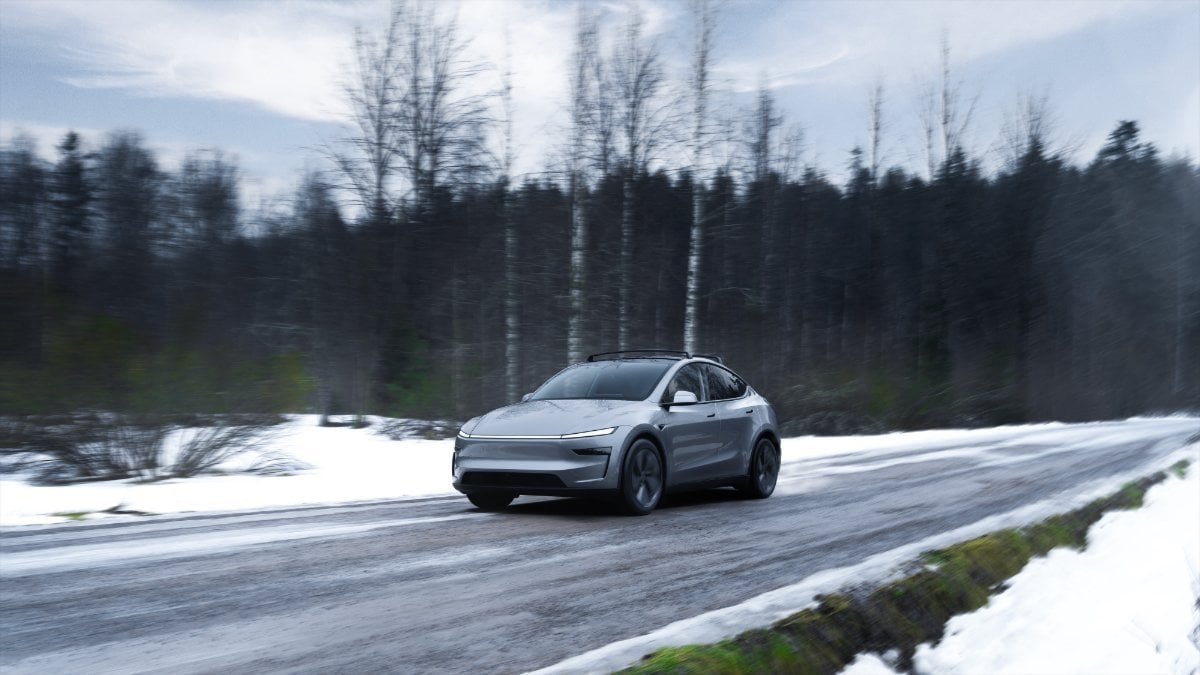 Silver 2026 Tesla Model Y Juniper está conduciendo un bosque nevado, un vehículo eléctrico pulido en movimiento con vistas de invierno